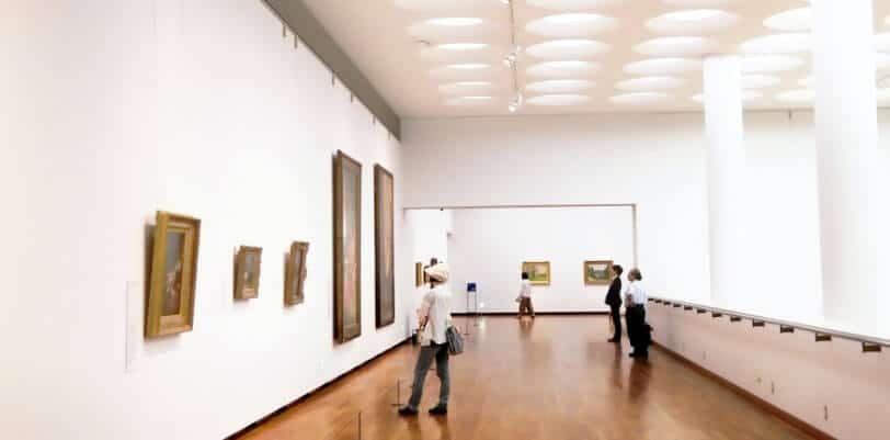 Spectators stand in a modern art museum viewing art, feature articles and content writing