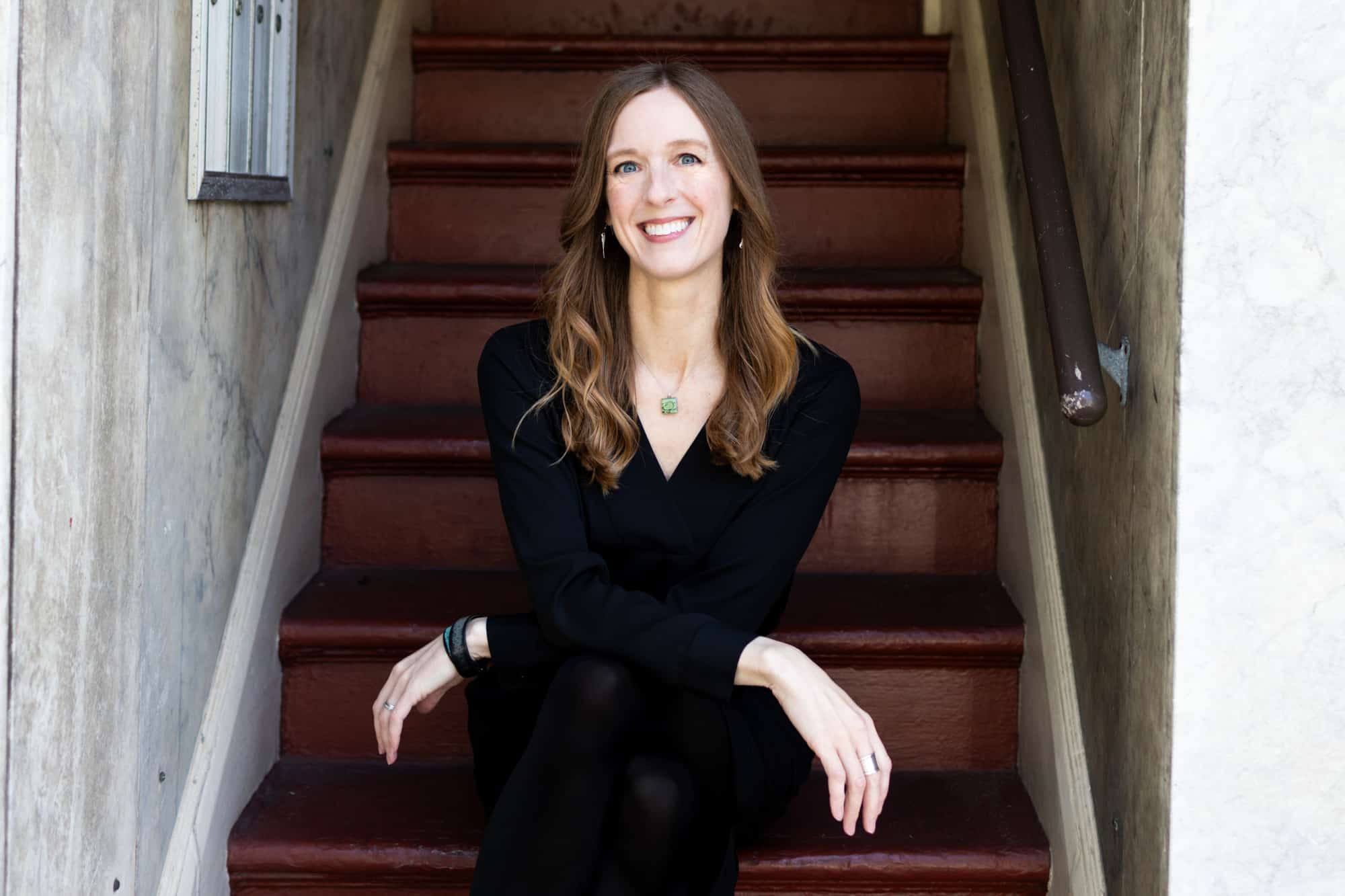 Renee Brincks, content writer and editor, sitting on stairs